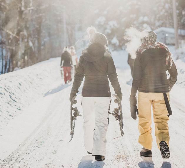 Lassen Sie die Landschaft beim Winterwandern bewusst auf sich wirken Gruppe wandert in Winterlandschaft