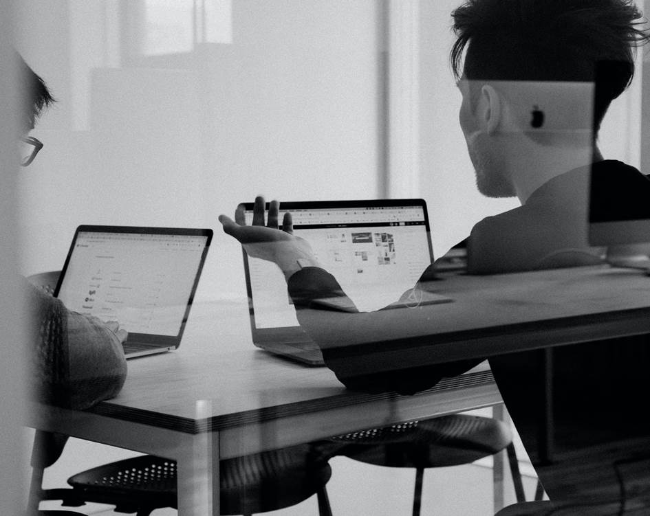 Vermitteln Sie uns in Ihrem Bewerbungsschreiben Ihre Motivation Leute sitzen am Computer und unterhalten sich