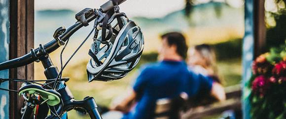 Traumhafte MTB-Strecken und idyllische Radtouren - Genießen Sie die Natur der Region Paar sitz auf Parkbank, ein Rad im Vordergrund