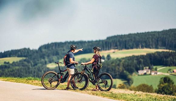 Erholen Sie sich nach einer Rad-Tour im warmen Thermalwasser Radfahrer in hügeliger Landschaft
