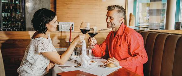 Genießen Sie das feine 4-Gang-Dinner in Buffetform im Restaurant China Grill Paar im Restaurant stößt mit Wein an