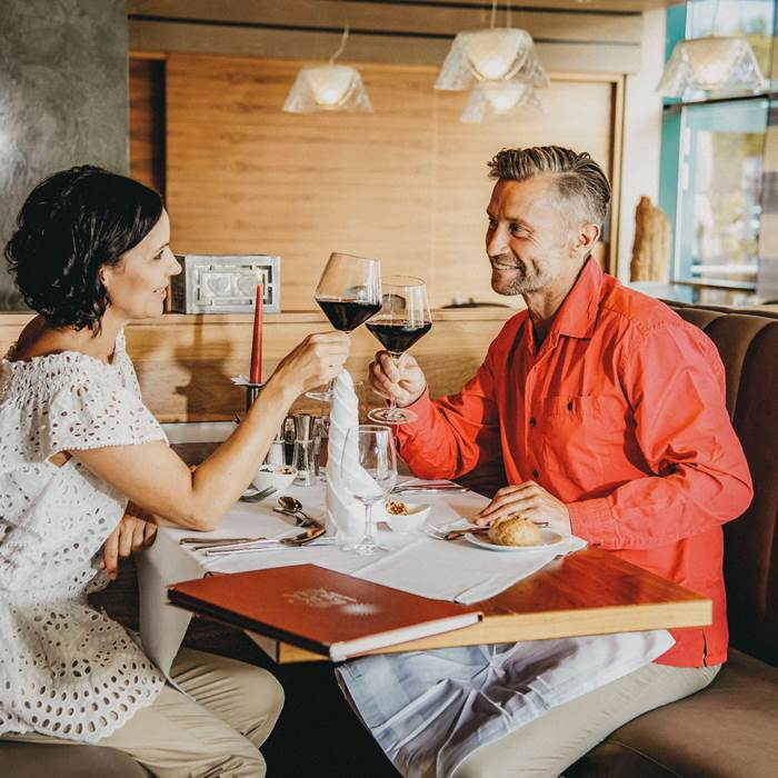 Couple in restaurant toasts with wine