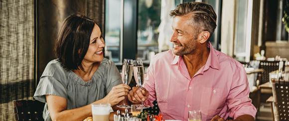 Unser Frühstücksangebot ist auch für Tagesgäste - Reservieren Sie noch heute Paar stößt mit Sekt beim Frühstück an