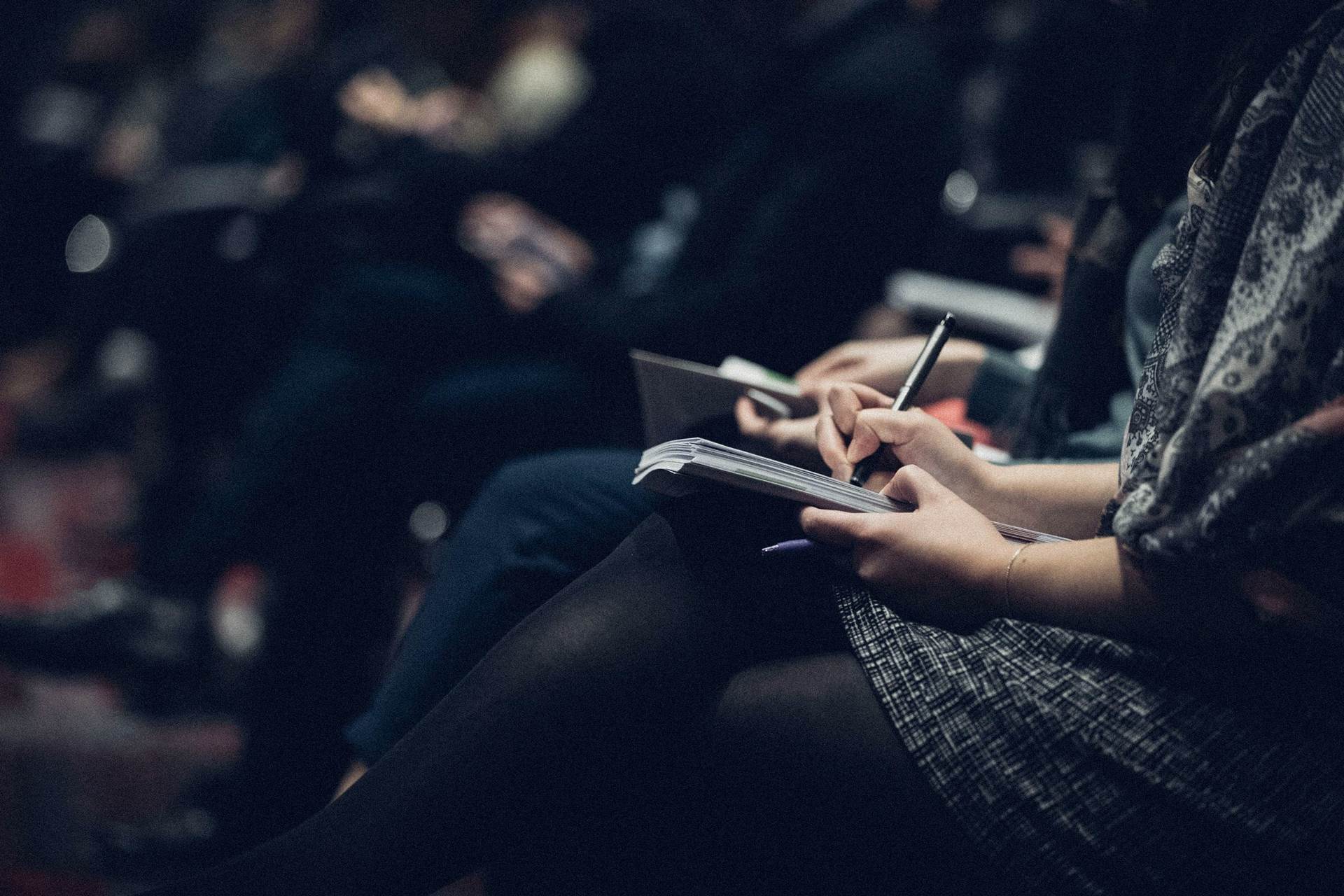 Gruppe von Leuten schreibt in Notizbücher