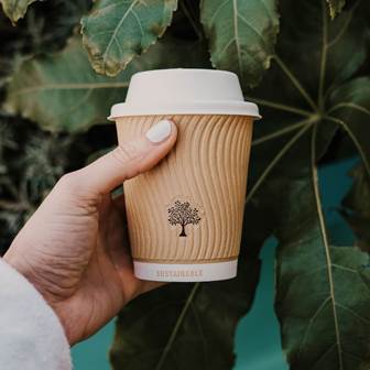 Unsere Becher sind aus Biokunststoff aus Kartoffel- oder Maisstärke und Milchsäure Kaffeebecher vor Blättern